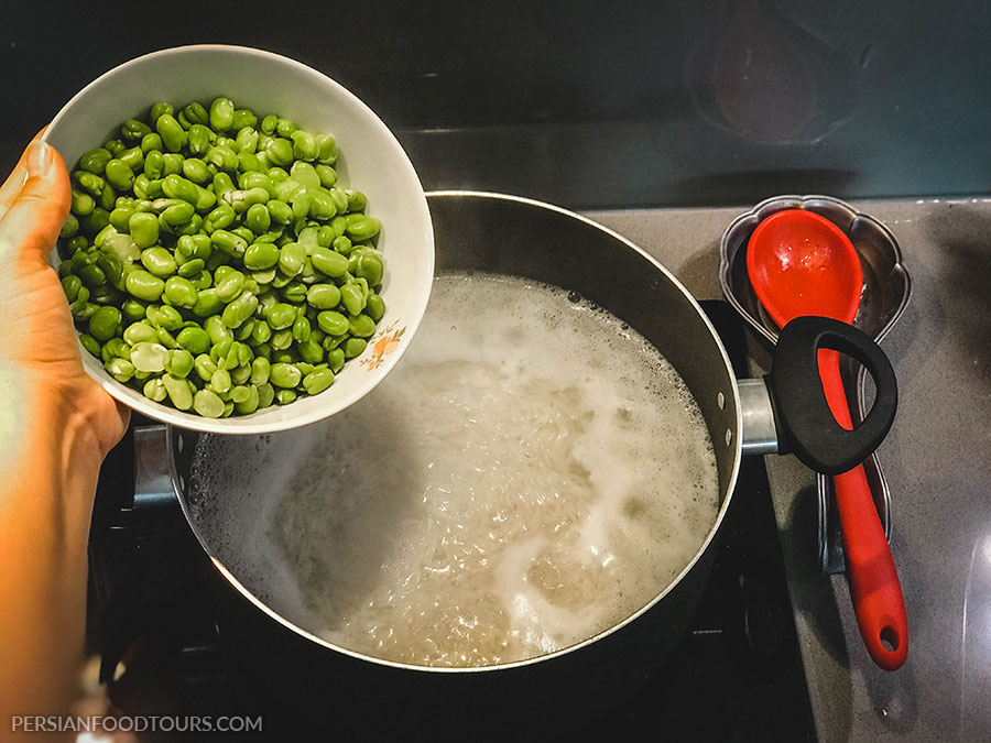 adding broad beans to the rice-baghali polo